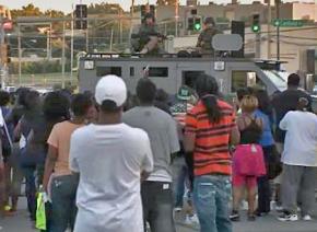 Police train machine guns on a crowd of protesters in Ferguson, Mo.